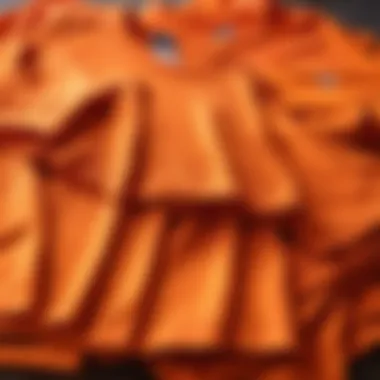 A selection of orange t-shirts arranged neatly on a table