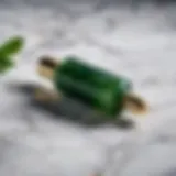 A close-up of a jade roller on a marble surface